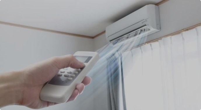 air conditioning unit with a hand holding a remote